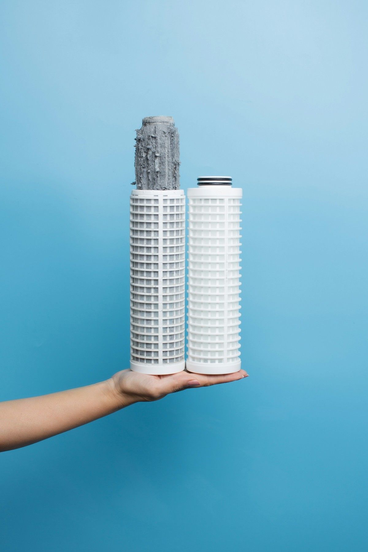 Two replacement filter cartridges held in one hand